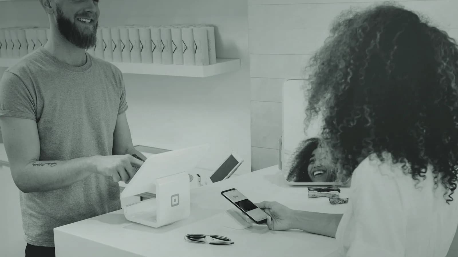 Small business owner completing a customer payment at a modern retail counter
