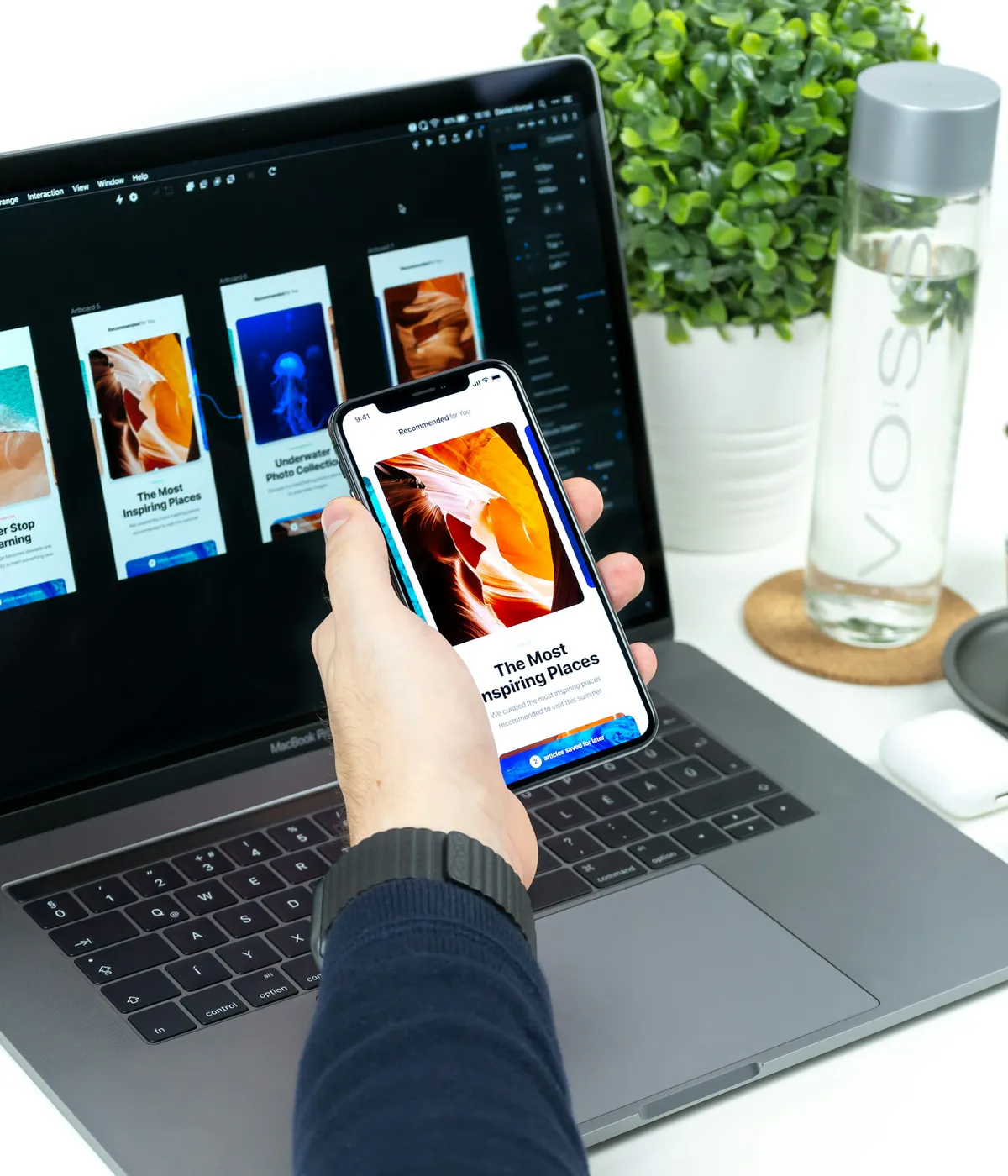 Designer testing a storefront interface across laptop and smartphone screens